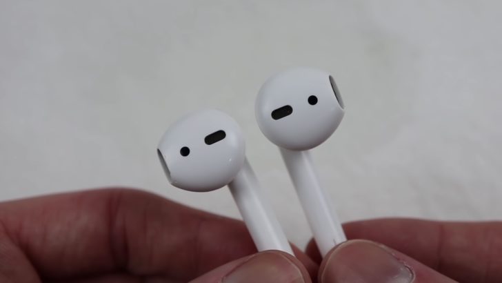 Photo of person holding airpods showing the proximity sensors