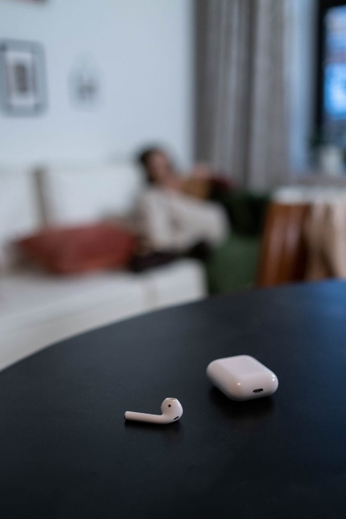 Photo of one airpod on the table with charging case