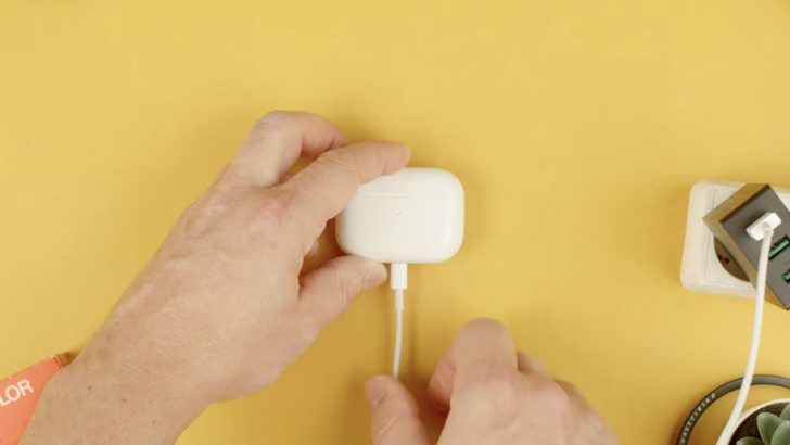 Photo of person charging the airpods charging case via lightning cable