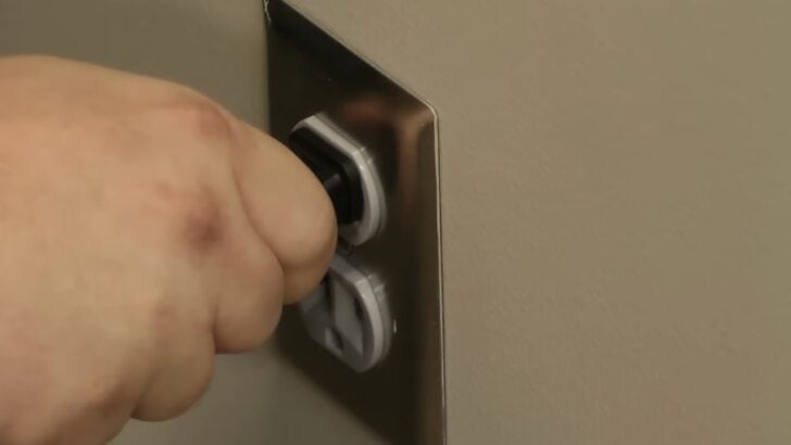 Photo of person unplugging vizio tv from the wall outlet