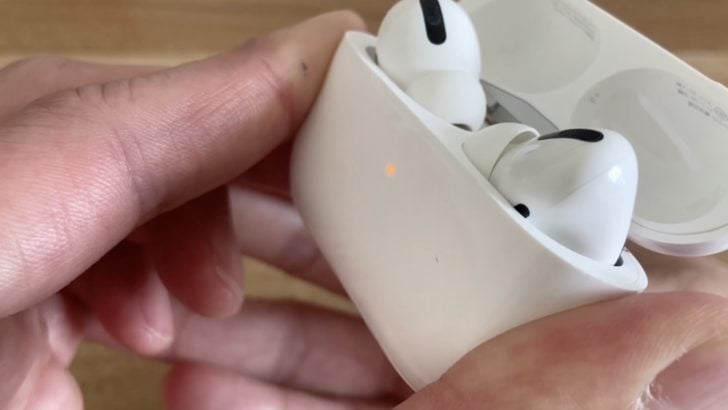 Picture of person resetting airpods