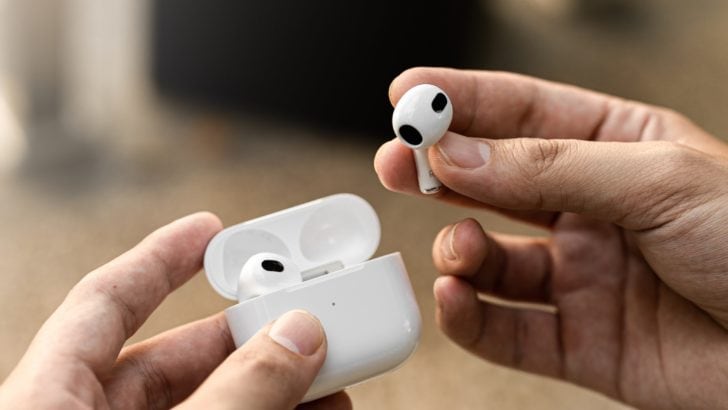 Photo of person inserting airpods in the charging case
