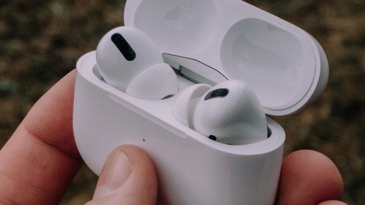Photo of person holding airpods pro inside case with open lid