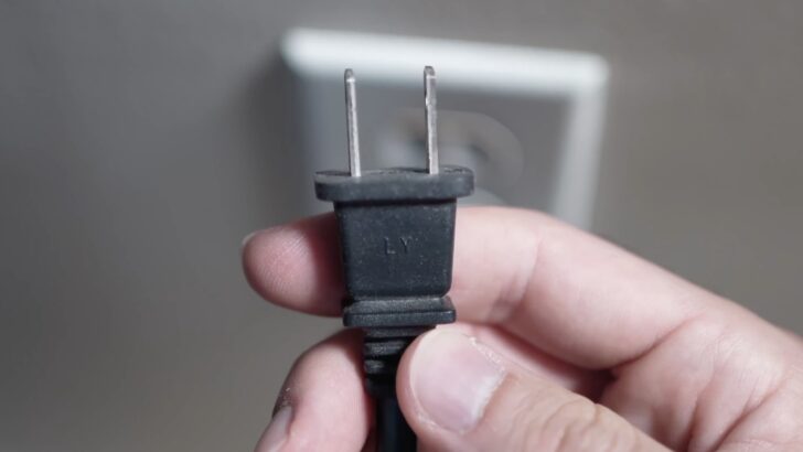 Photo of person unplugging hisense tv from the power outlet