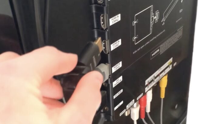 Photo of person plugging hdmi cable on samsung tv