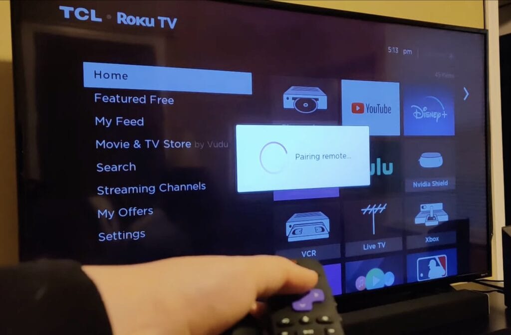 Photo of person pairing remote to tcl tv