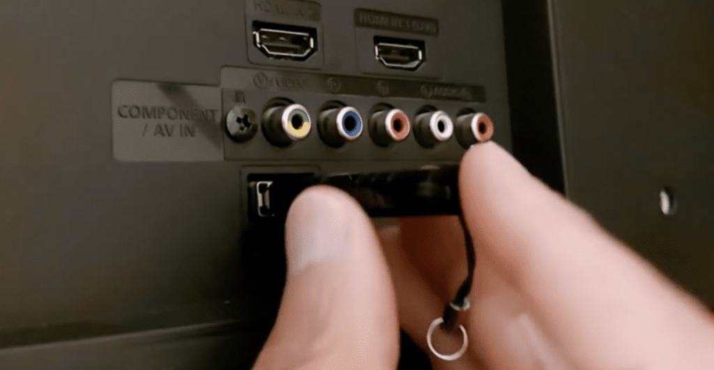Photo of a person plugging a USB flash drive into a TV to install a firmware update