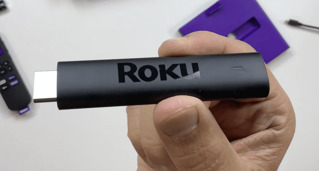 Photo of someone holding a Roku streaming stick