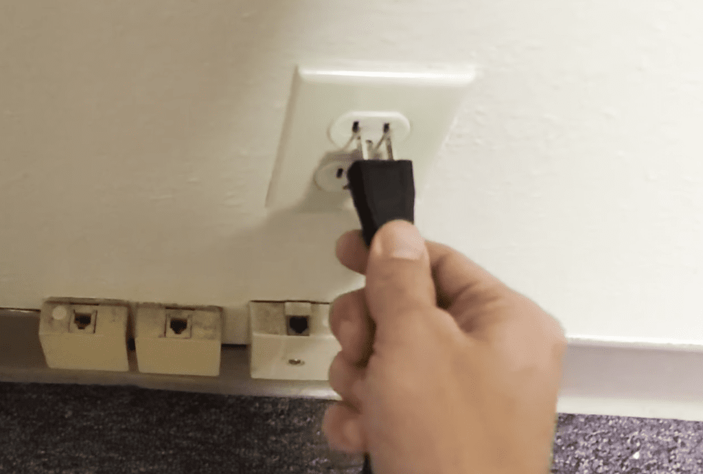 Photo of a person unplugging a Samsung TV from the power outlet