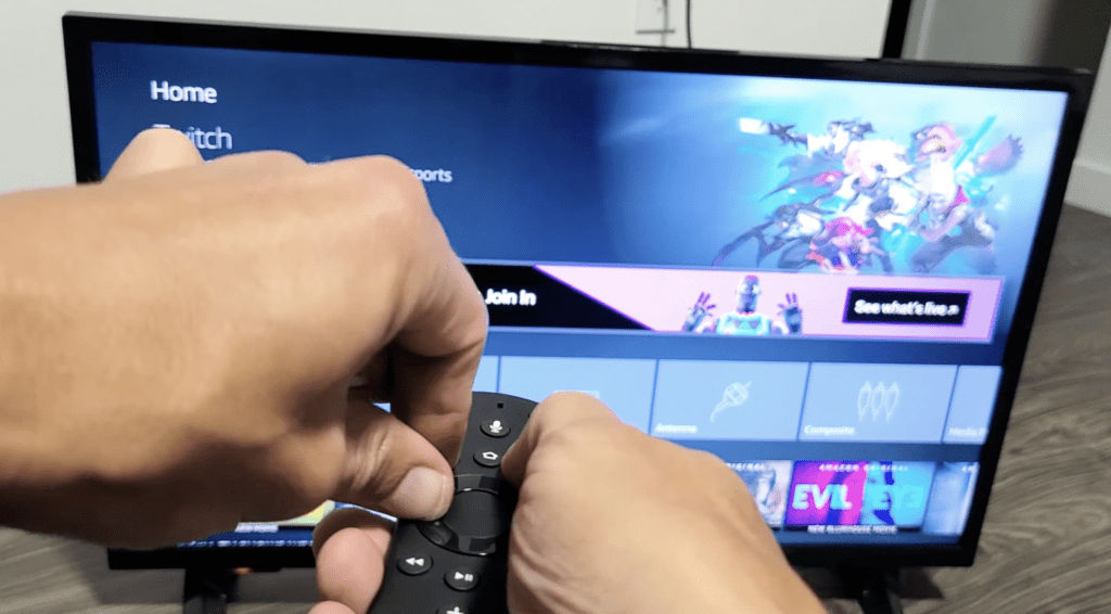 Photo of a person resetting an Insignia TV remote by pressing the Menu, Back, and left side of the navigation ring for 12 seconds