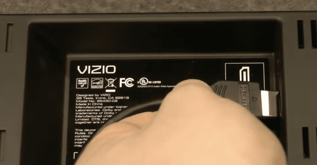 Photo of someone reseating the HDMI connection of a Vizio TV