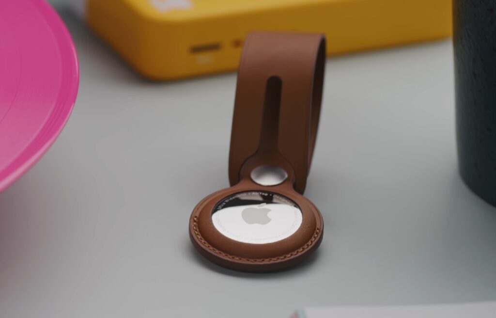 an Apple AirTag in a brown holder