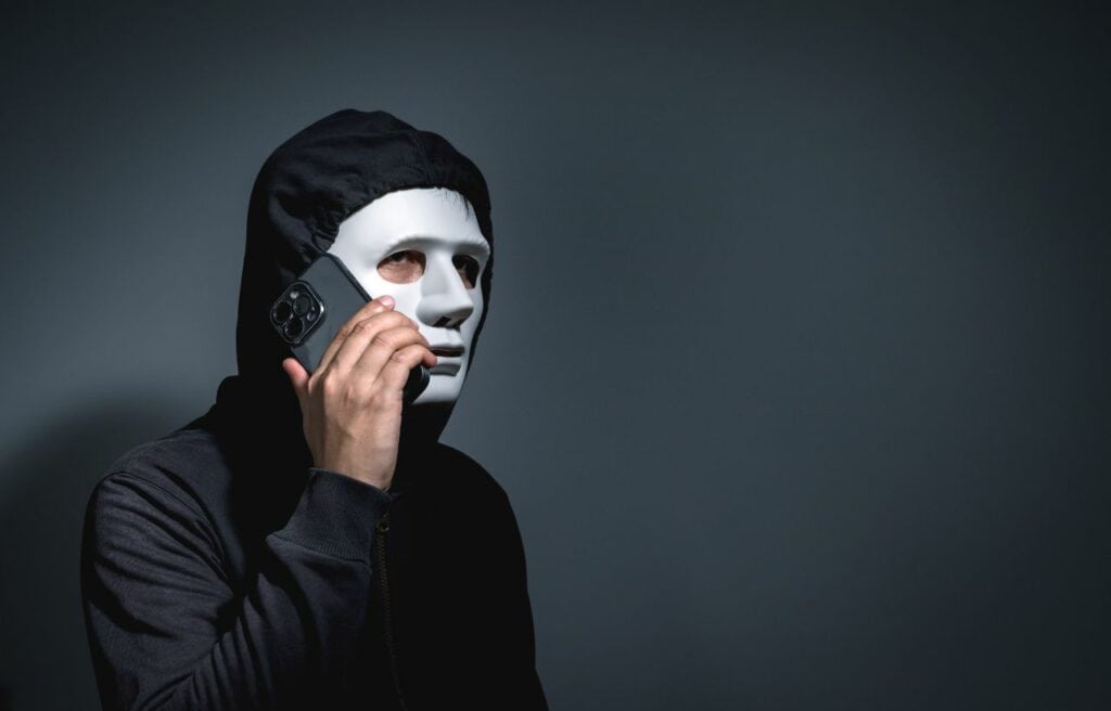 A man wearing a mask while making a call