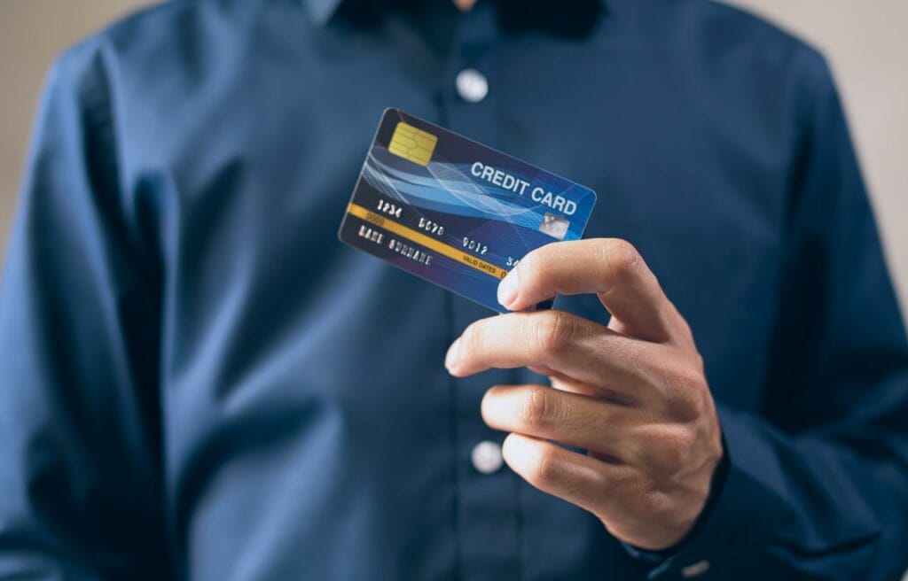man in blue suit holding a credit card