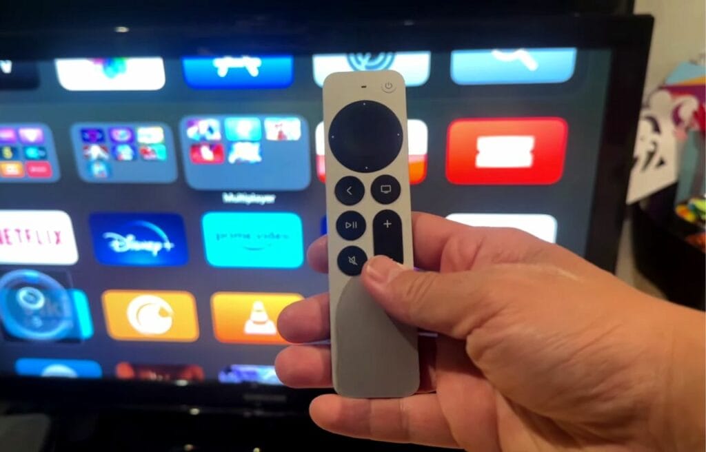Holding an Apple TV remote against a TV screen