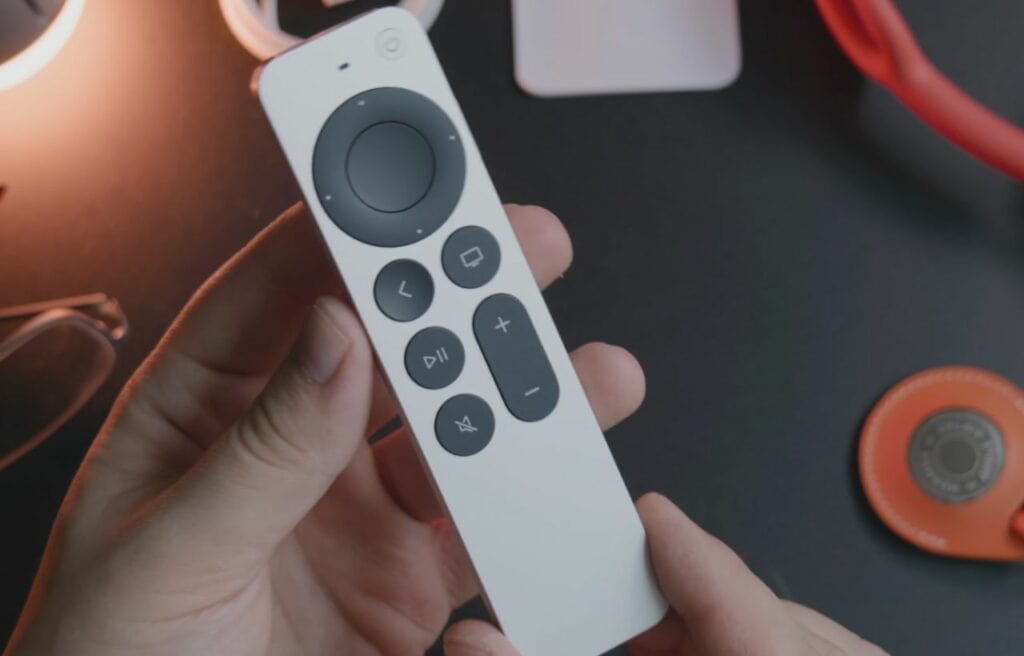 Holding an Apple TV remote