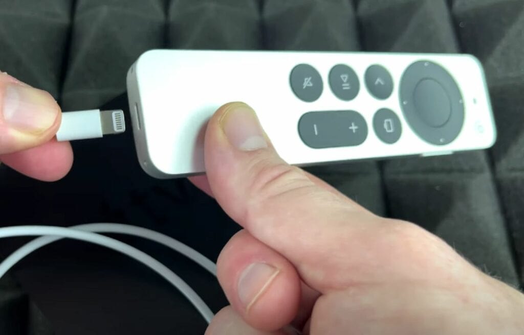 Holding a charger and an Apple TV remote