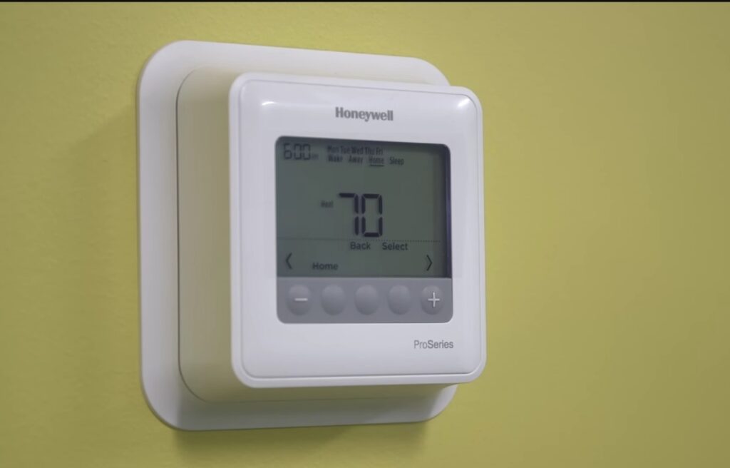 A Honeywell Thermostat on a yellow wall