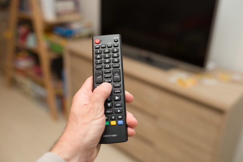 LG TV remote held by a man