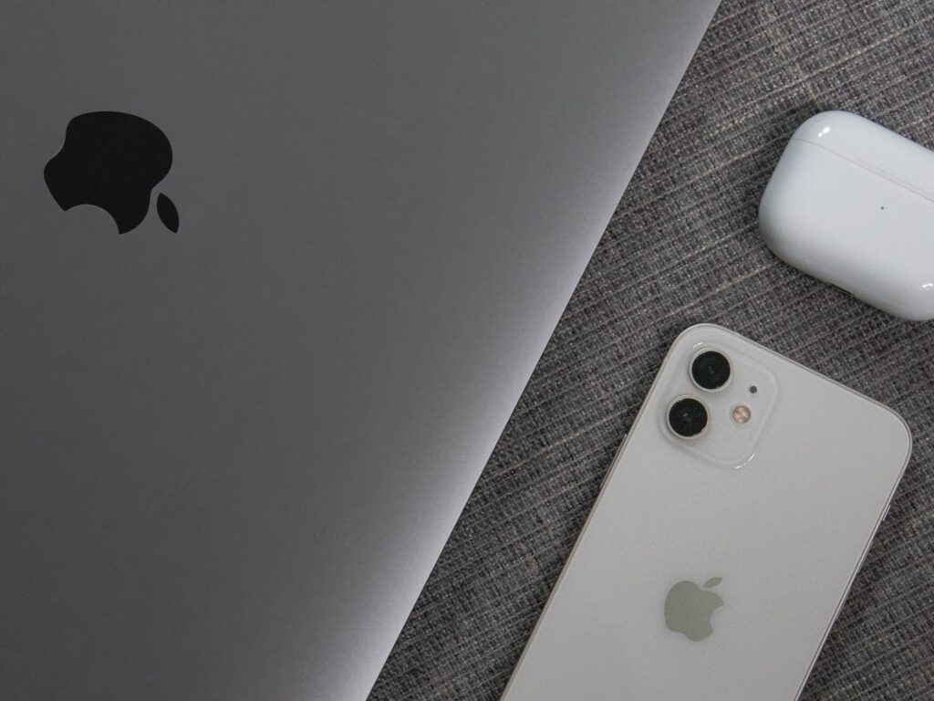 Apple products like Macbook, iPhone, and Airpods laying on a table