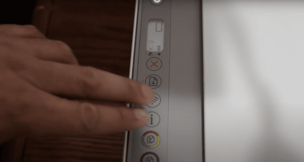 Man pressing Info button +  Wireless button on the HP printer
