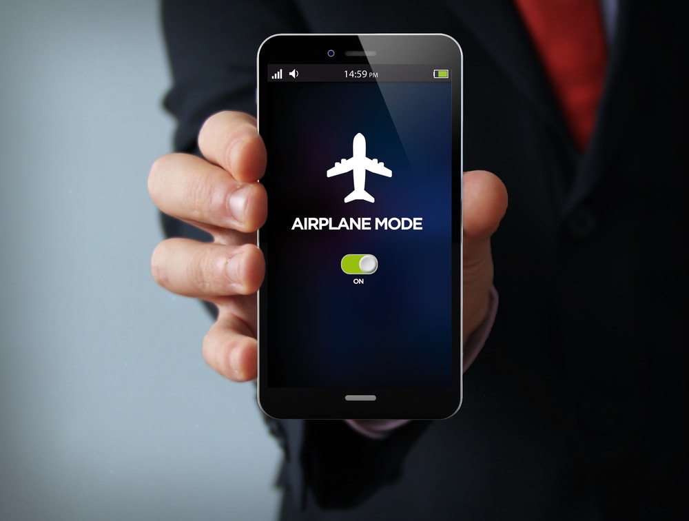businessman hand holding a phone with airplane mode on the screen