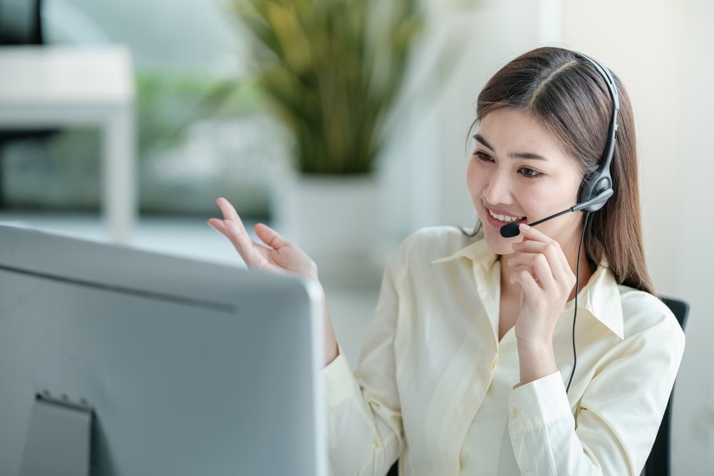 smiling female customer support phone operator at workplace
