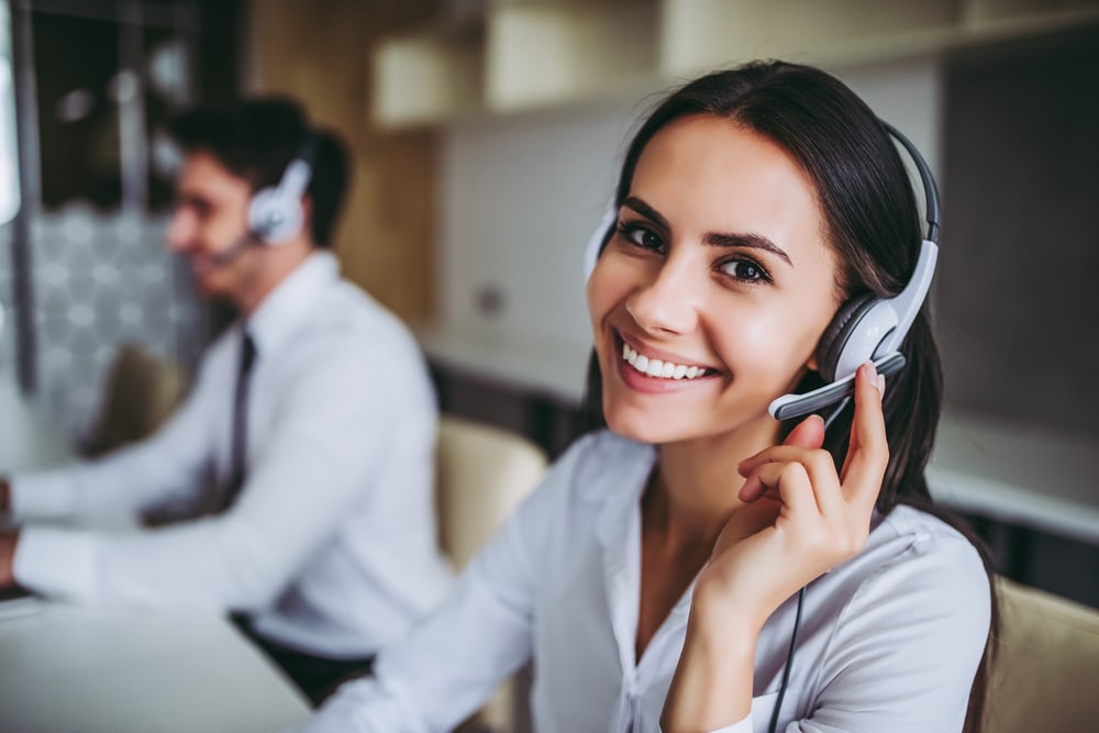 a female customer support specialist smiling for the camera