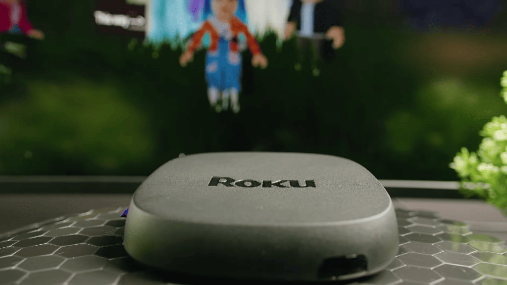 Roku Ultra streaming device with tv screen on the background